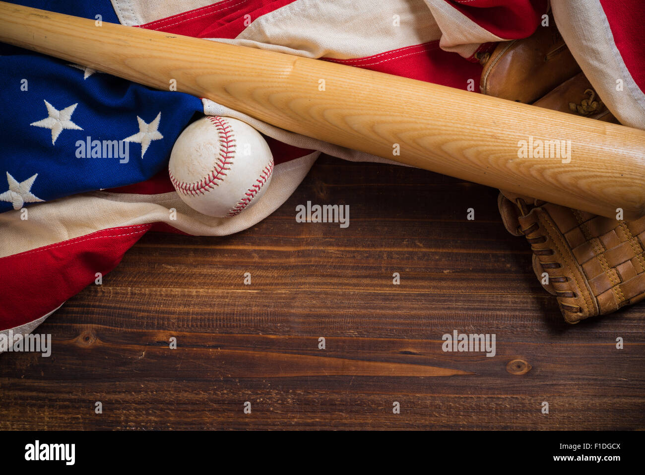Un vecchio, antichi bandiera americana con vintage attrezzatura da baseball su una panca in legno Foto Stock