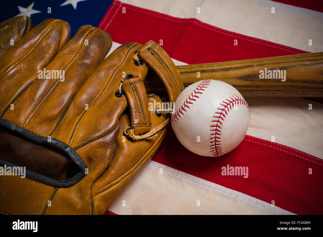 Un vecchio, antichi bandiera americana con vintage attrezzatura da baseball su una panca in legno Foto Stock
