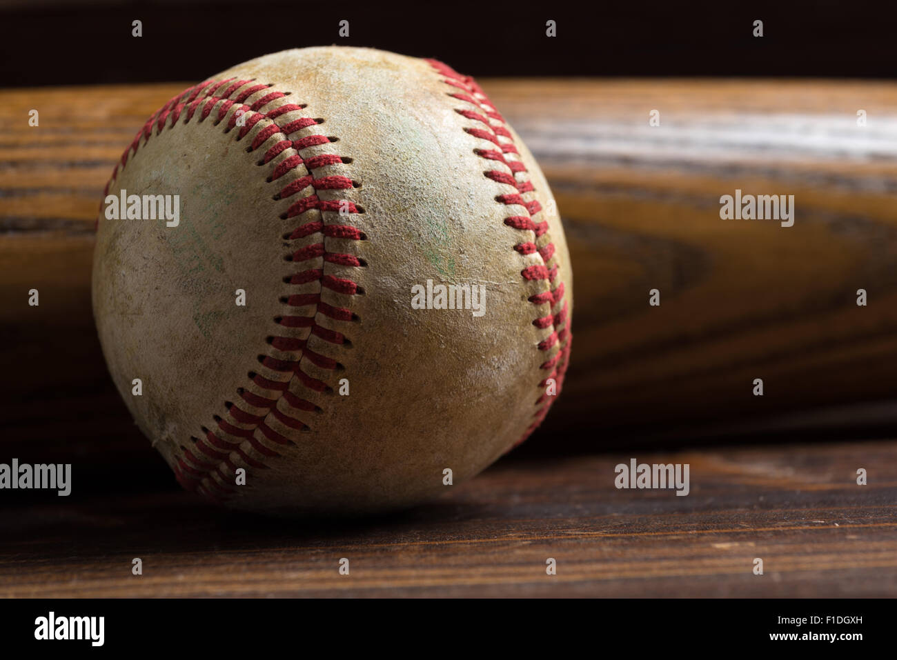 Attrezzatura da baseball: mazza di legno e la sfera su un asse di legno o di sfondo da banco Foto Stock