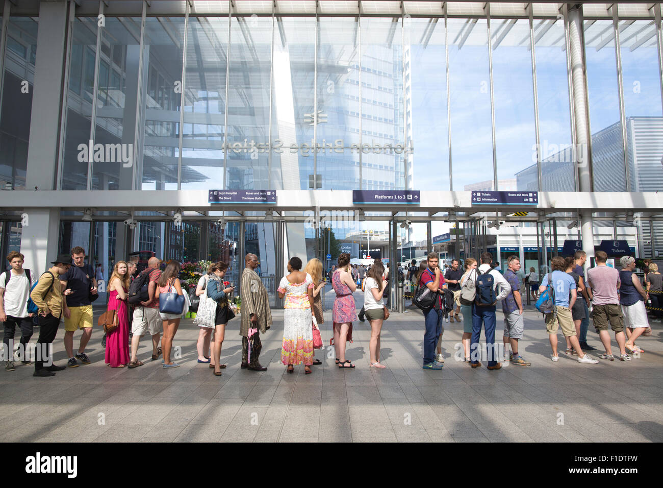 Code di estate pendolari fodera fino ad acquistare biglietti ferroviari a London Bridge stazione ferroviaria, Central London, England, Regno Unito Foto Stock