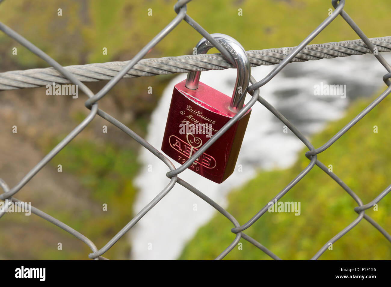 Un lucchetto d'amore attaccato alla recinzione intorno alla piattaforma panoramica sopra la cascata di Skogafoss in Islanda. Tema: Danni ambientali, vandalismo Foto Stock