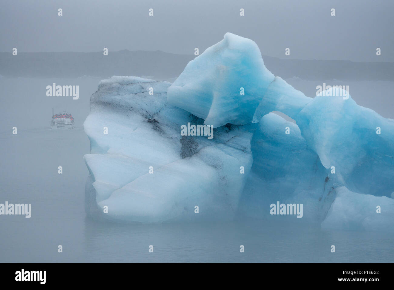 I turisti che prendono un tour in barca nella nebbia tra giganteschi iceberg nella laguna glaciale di Jokulsarlon in una giornata estiva nebbia in agosto, Islanda Foto Stock