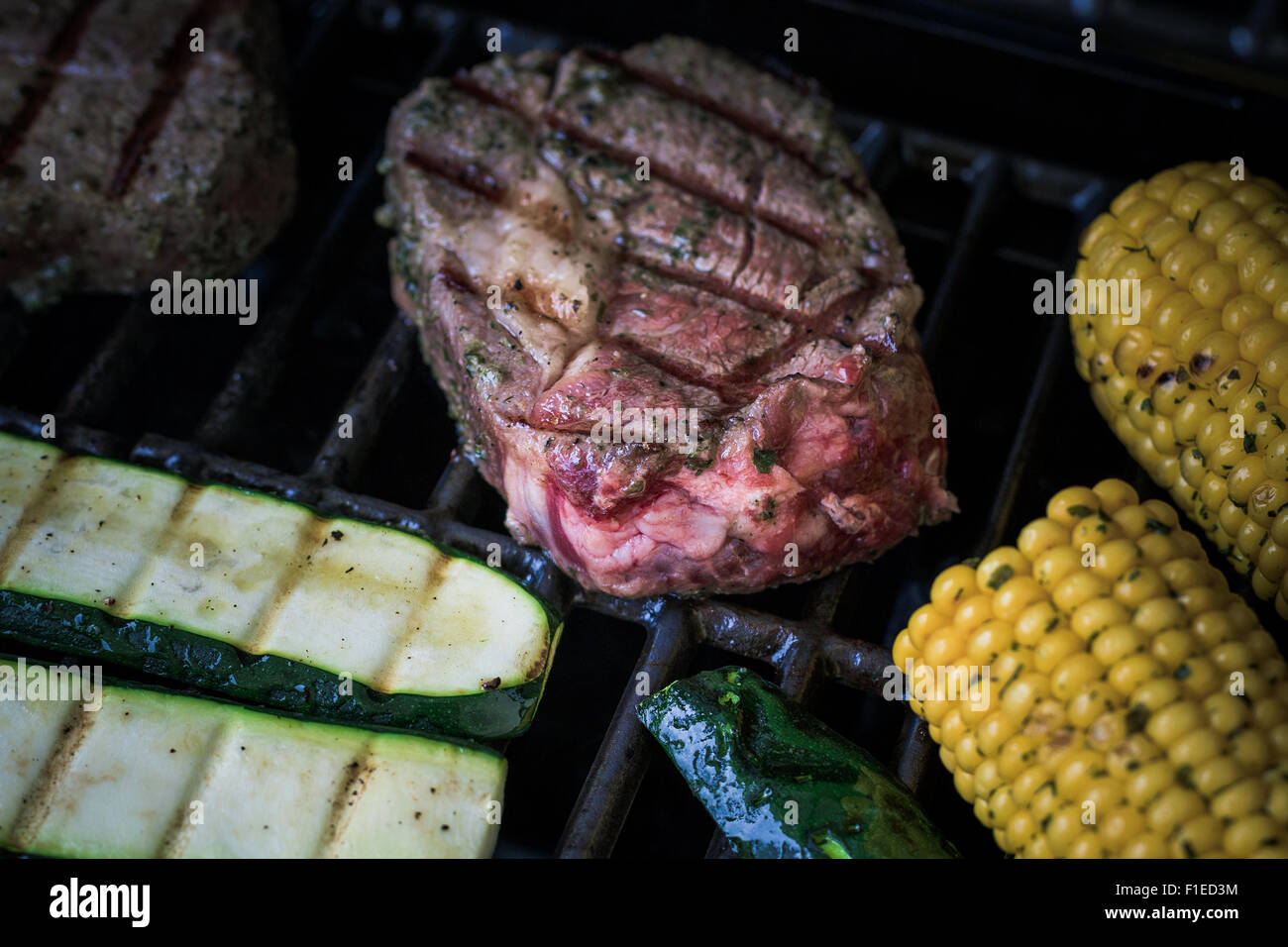 Costata di manzo con zucchine e mais sul grill, soft focus, vista dall'alto Foto Stock