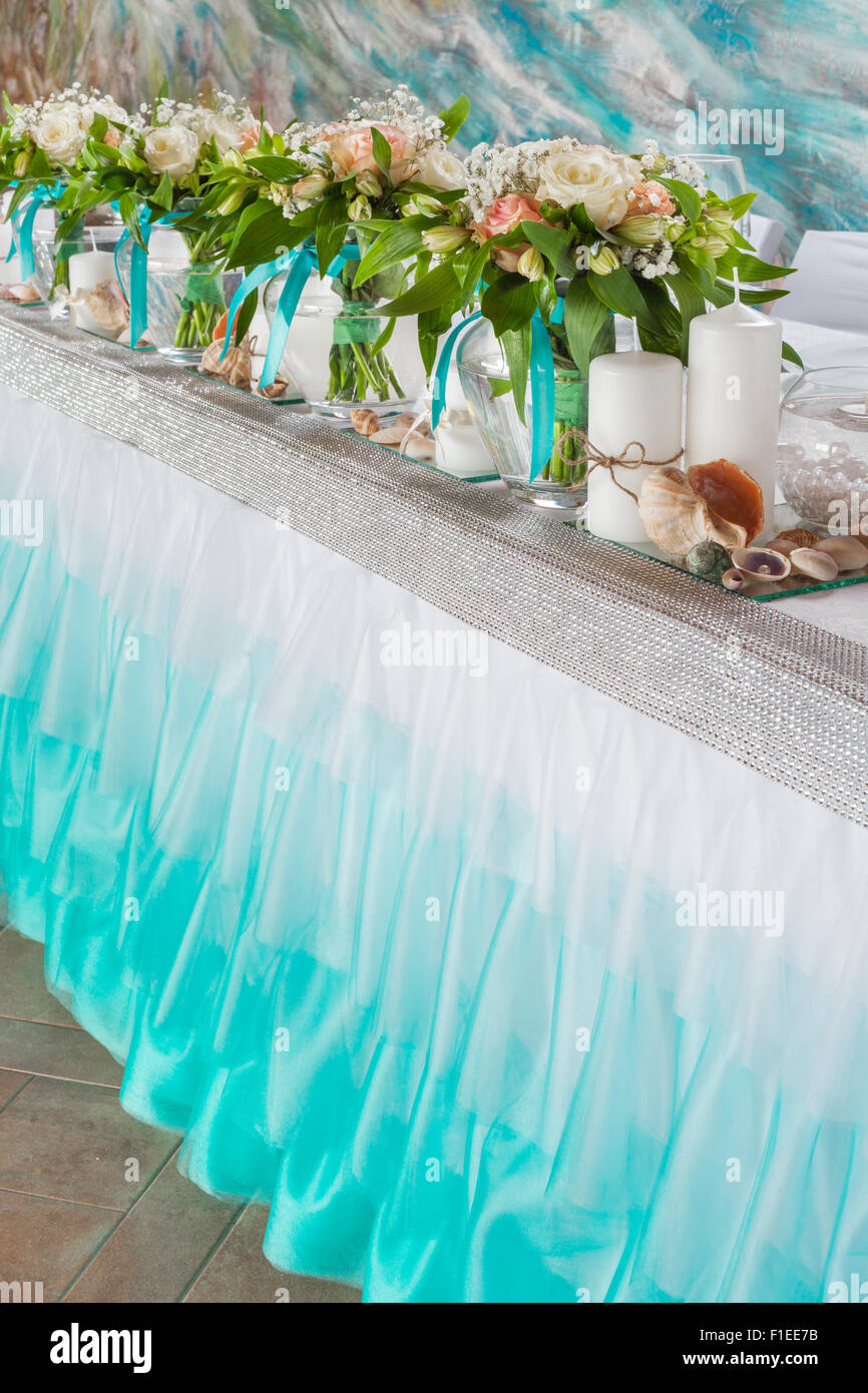 Bellissimi mazzi di fiori e decorazioni sul tavolo in sala per matrimoni. Foto Stock