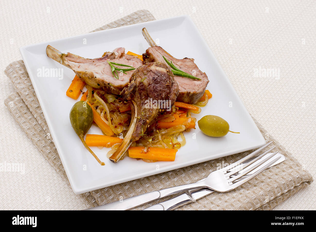 Grigliata di carré di agnello con olive, capperi e carote, vista dall'alto Foto Stock