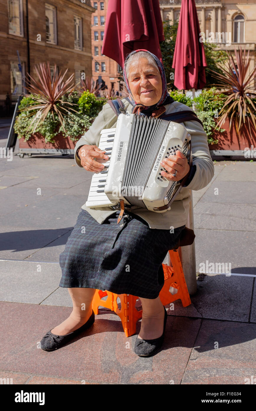 Donna rumena di suonare la fisarmonica e musicista di strada in Buchanan Street, Glasgow, Scotland, Regno Unito Foto Stock