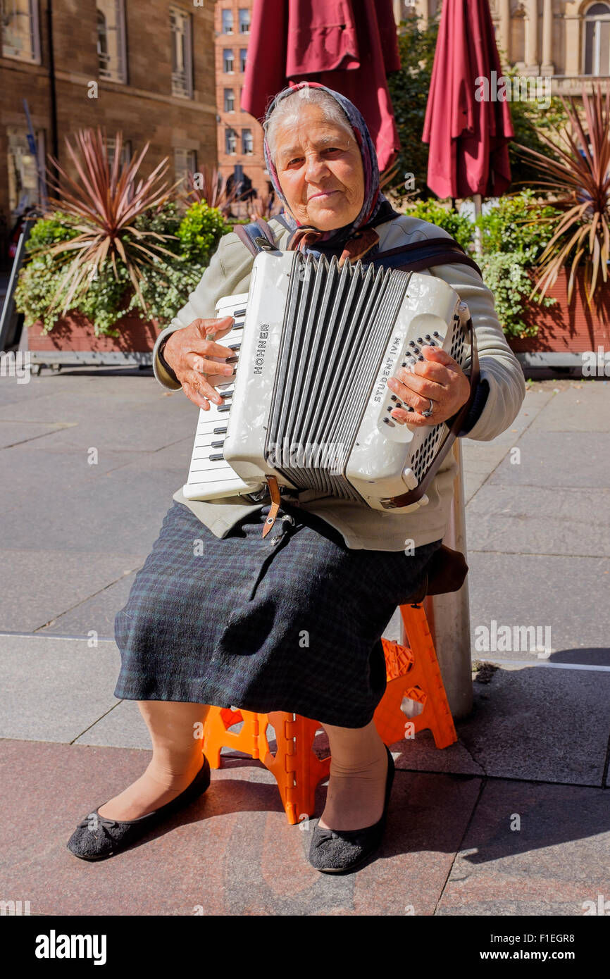 Donna rumena di suonare la fisarmonica e musicista di strada in Buchanan Street, Glasgow, Scotland, Regno Unito Foto Stock