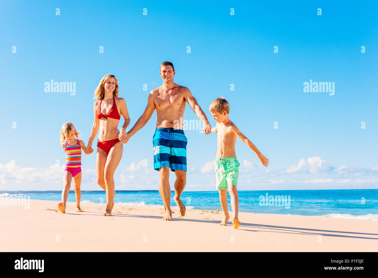 Vacanza in famiglia. La famiglia felice avendo divertimento sulla calda bella spiaggia soleggiata. Lo stile di vita di estate Foto Stock