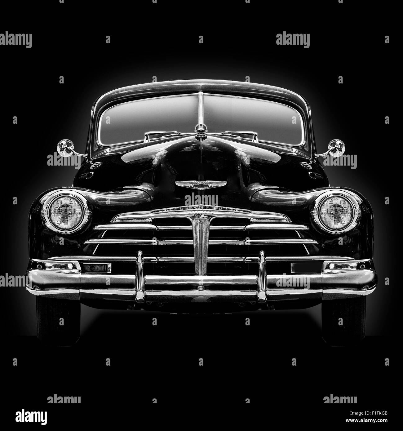Un b&w testa in vista di un 1950 Chevrolet Coupe messo k.o. su uno sfondo nero formato quadrato dell'immagine. Foto Stock