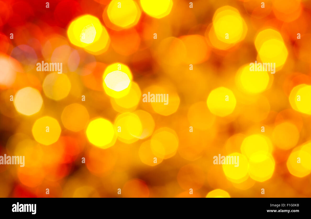 Abstract sfondo sfocato - di colore giallo scuro e rosso scintillanti luci di Natale bokeh di le ghirlande elettriche su albero di Natale Foto Stock