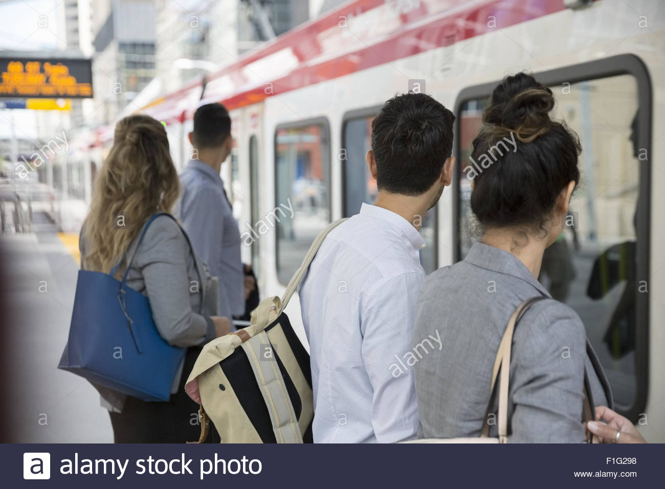 La gente di affari in attesa a bordo del treno sulla piattaforma Foto Stock