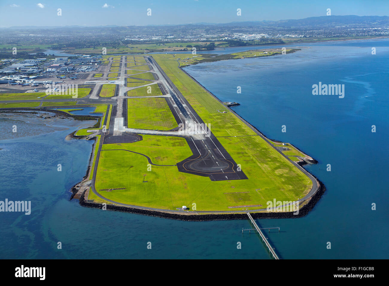 Pista principale all'Aeroporto di Auckland, e Manukau Harbour, Auckland, Isola del nord, Nuova Zelanda - aerial Foto Stock