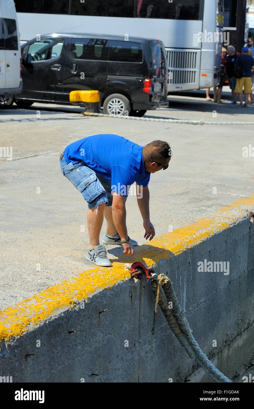 Un equipaggio delle navi degli stati ottenere pronto per rilasciare la fune consentendo la barca di discostarsi Santorini Grecia Foto Stock