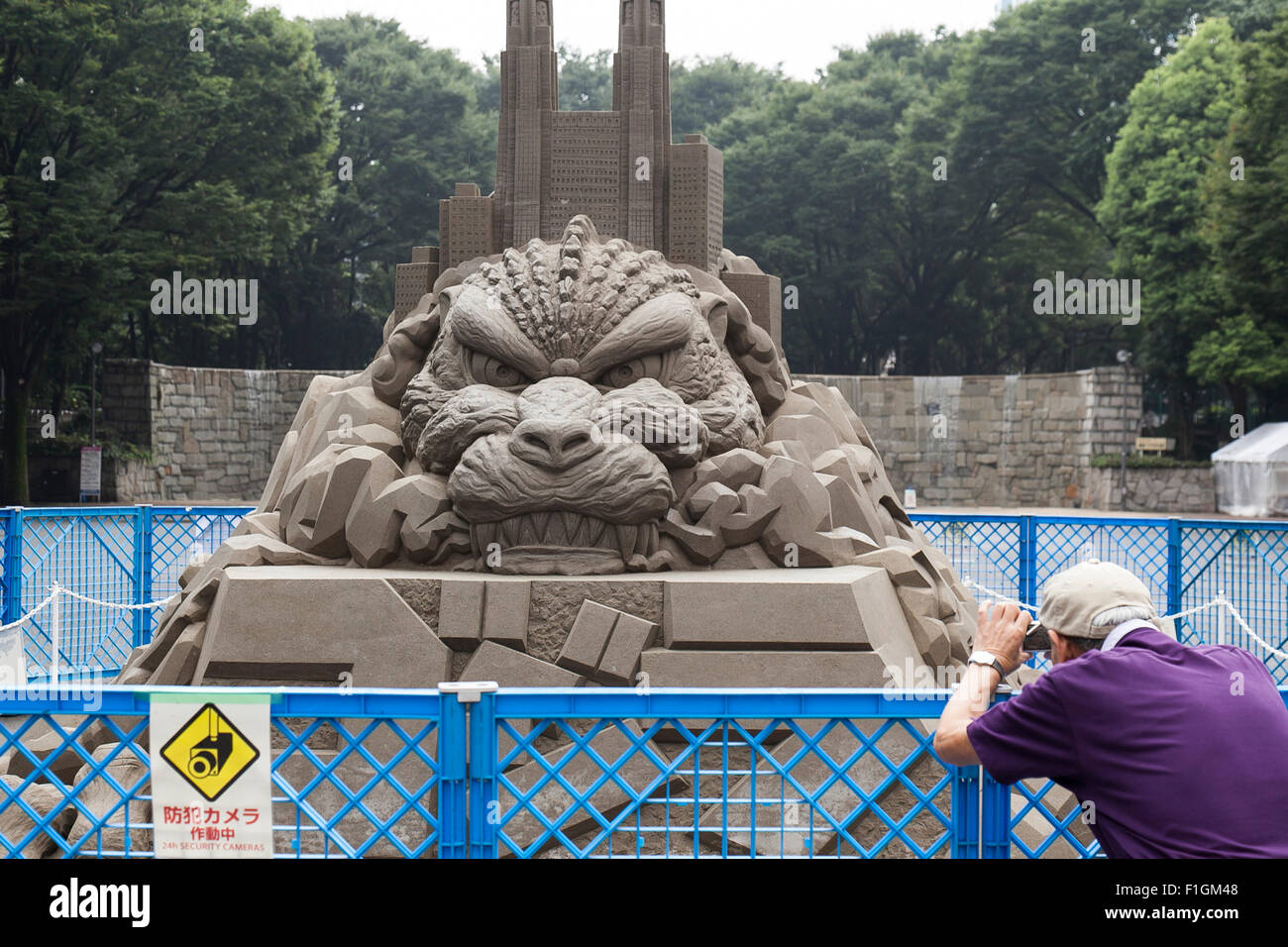 Un uomo prende una foto dell'Opera ''Godzilla'' da Toshihiko Hosaka a Shinjuku Central Park il 1 settembre 2015, Tokyo, Giappone. Varie opere di arte contemporanea sono mostrati come parte dei creatori di Shinjuku' Festa 2015. Le manifestazioni hanno luogo nella zona di edifici per uffici, sovrappassi e luoghi pubblici tra cui stazione di Shinjuku, Kabukicho ed edificio centrale fino al 6 settembre. © Rodrigo Reyes Marin/AFLO/Alamy Live News Foto Stock