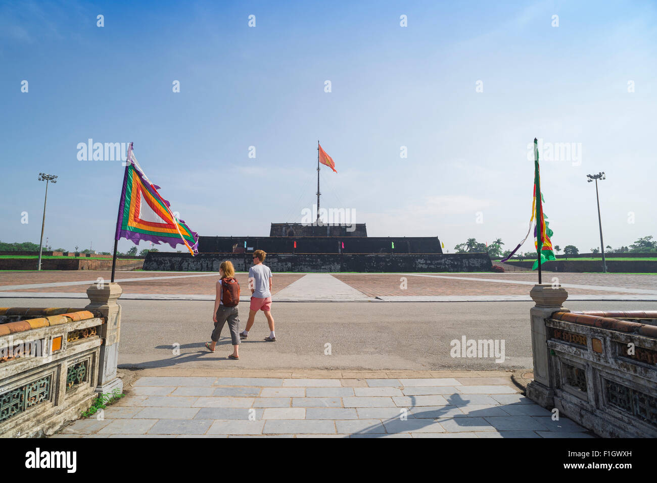 Hue Vietnam turisti, una giovane coppia di testa oltre la bandiera imperiale torre (Cot Co) sul loro modo fuori la cittadella di Hue, Vietnam. Foto Stock