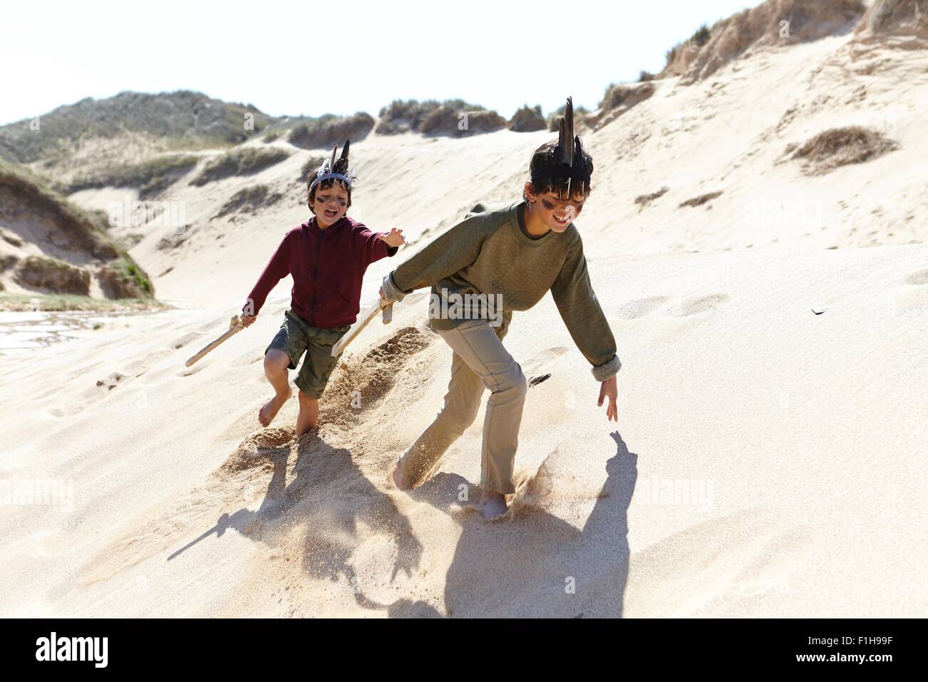 Due ragazzi, che indossa abiti fantasiosi, giocando sulla sabbia Foto Stock