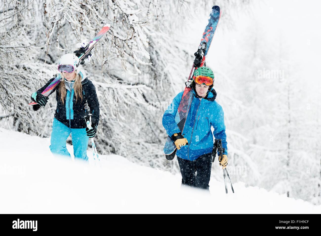 L uomo e la donna a piedi nella neve con gli sci Foto Stock