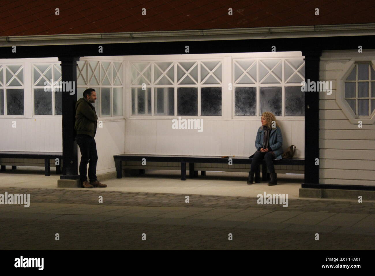 Richard Harrington stella dell entroterra / y gwyll riprese in Aberystwyth's promenade shelter Wales UK Foto Stock