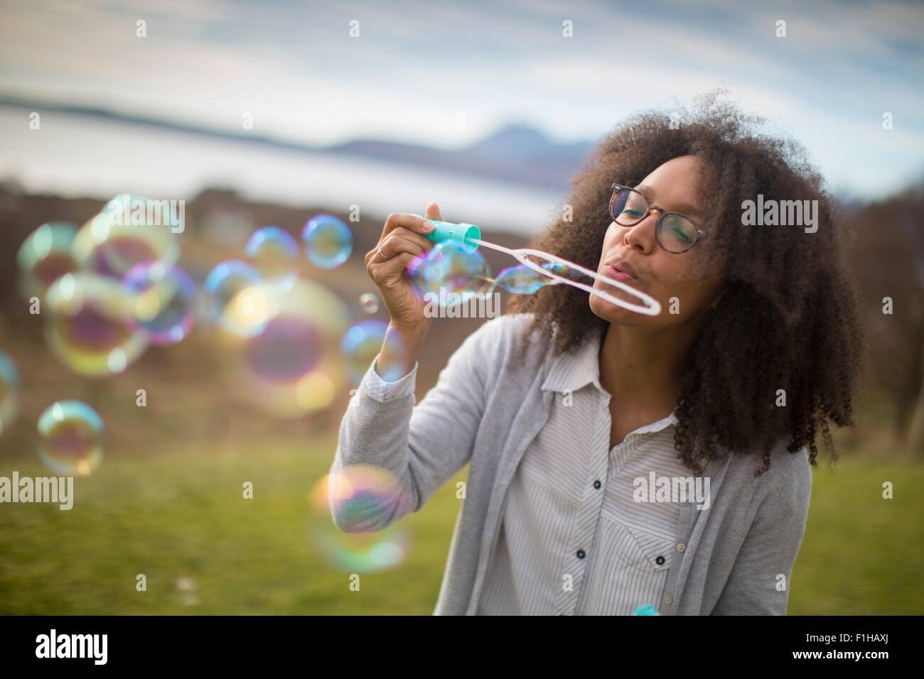 Metà donna adulta soffiare bolle Foto Stock