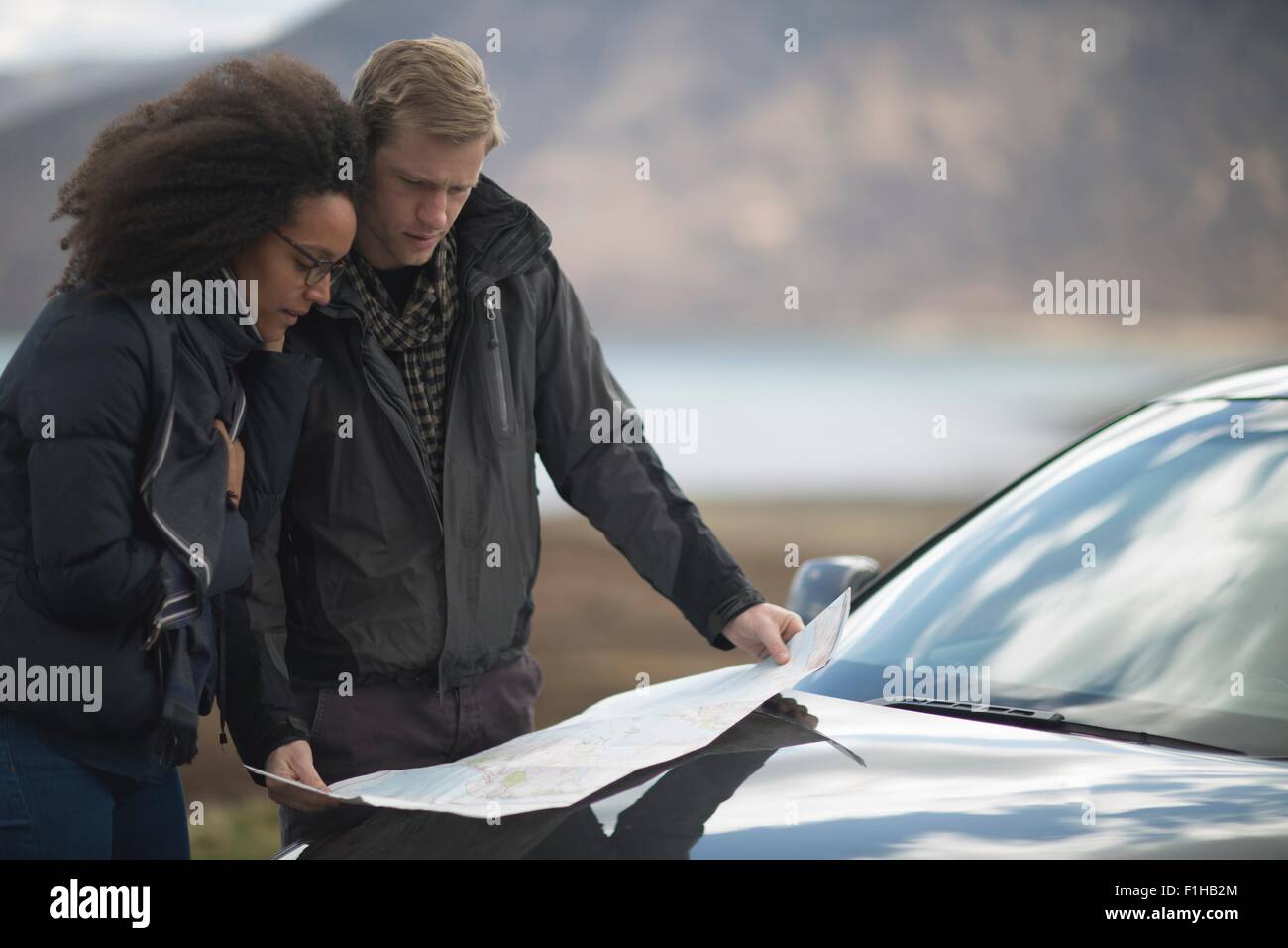 Metà adulto giovane in auto con mappa Foto Stock