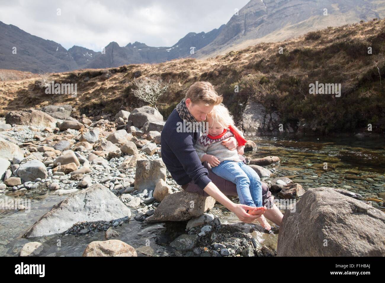 Padre e figlio seduti sulle rocce, Fairy Piscine, Isola di Skye, Ebridi, Scozia Foto Stock