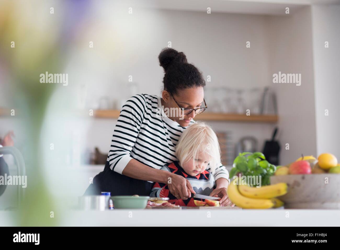Madre aiutare figlio di preparare il cibo in cucina Foto Stock