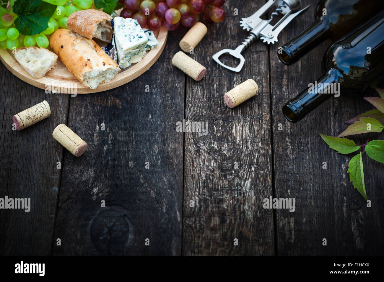 Le bottiglie di vino con foglie d'uva su sfondo di legno con copia spazio, il fuoco selettivo Foto Stock