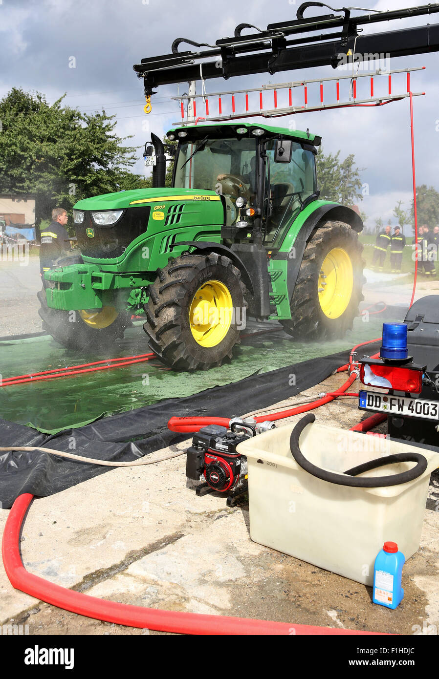 Dresden, Germania. 2 Sep, 2015. Un trattore è disinfettato durante un esercizio in materia di lotta contro la peste suina africana in un piggery a Dresda, in Germania, 2 settembre 2015. L'Ufficio veterinario di Dresda praticata insieme con i vigili del fuoco di trattare con la peste suina africana. Originariamente dall Africa non esistono vaccini contro la malattia virale. Gli allevamenti di suini entro tre chilometri delle aziende agricole colpite devono essere macellati. Per data, i casi si sono verificati in Russia, nei paesi baltici e in Polonia orientale. Fotografia: JAN WOITAS/dpa/Alamy Live News Foto Stock