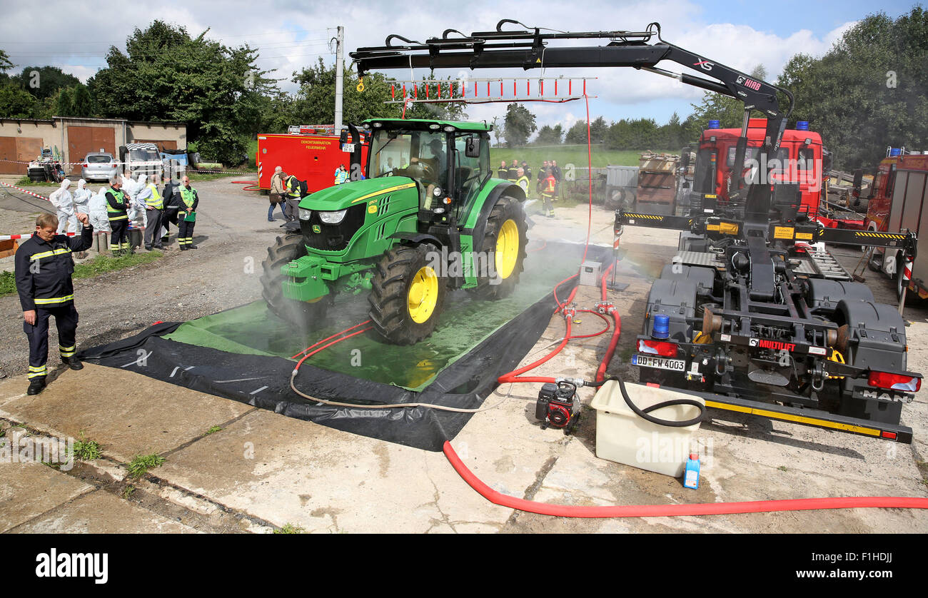 Dresden, Germania. 2 Sep, 2015. Un trattore è disinfettato durante un esercizio in materia di lotta contro la peste suina africana in un piggery a Dresda, in Germania, 2 settembre 2015. L'Ufficio veterinario di Dresda praticata insieme con i vigili del fuoco di trattare con la peste suina africana. Originariamente dall Africa non esistono vaccini contro la malattia virale. Gli allevamenti di suini entro tre chilometri delle aziende agricole colpite devono essere macellati. Per data, i casi si sono verificati in Russia, nei paesi baltici e in Polonia orientale. Fotografia: JAN WOITAS/dpa/Alamy Live News Foto Stock
