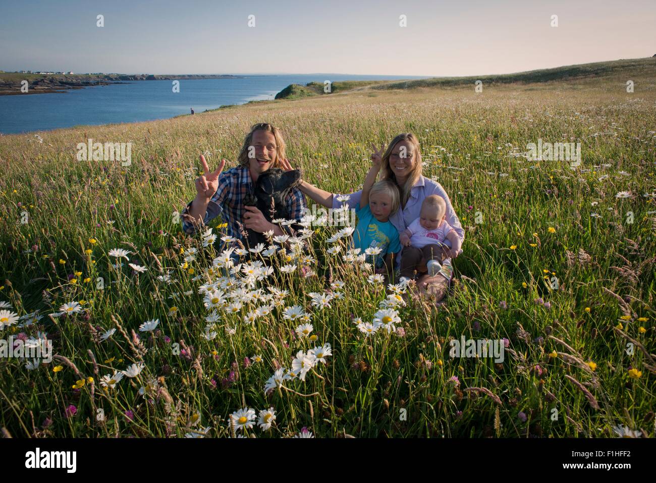 Ritratto di famiglia seduto su una collina, bianco strand, County Clare, Irlanda Foto Stock