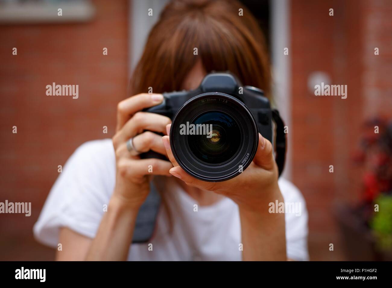 Metà donna adulta utilizzando la fotocamera digitale, faccia oscurata Foto Stock