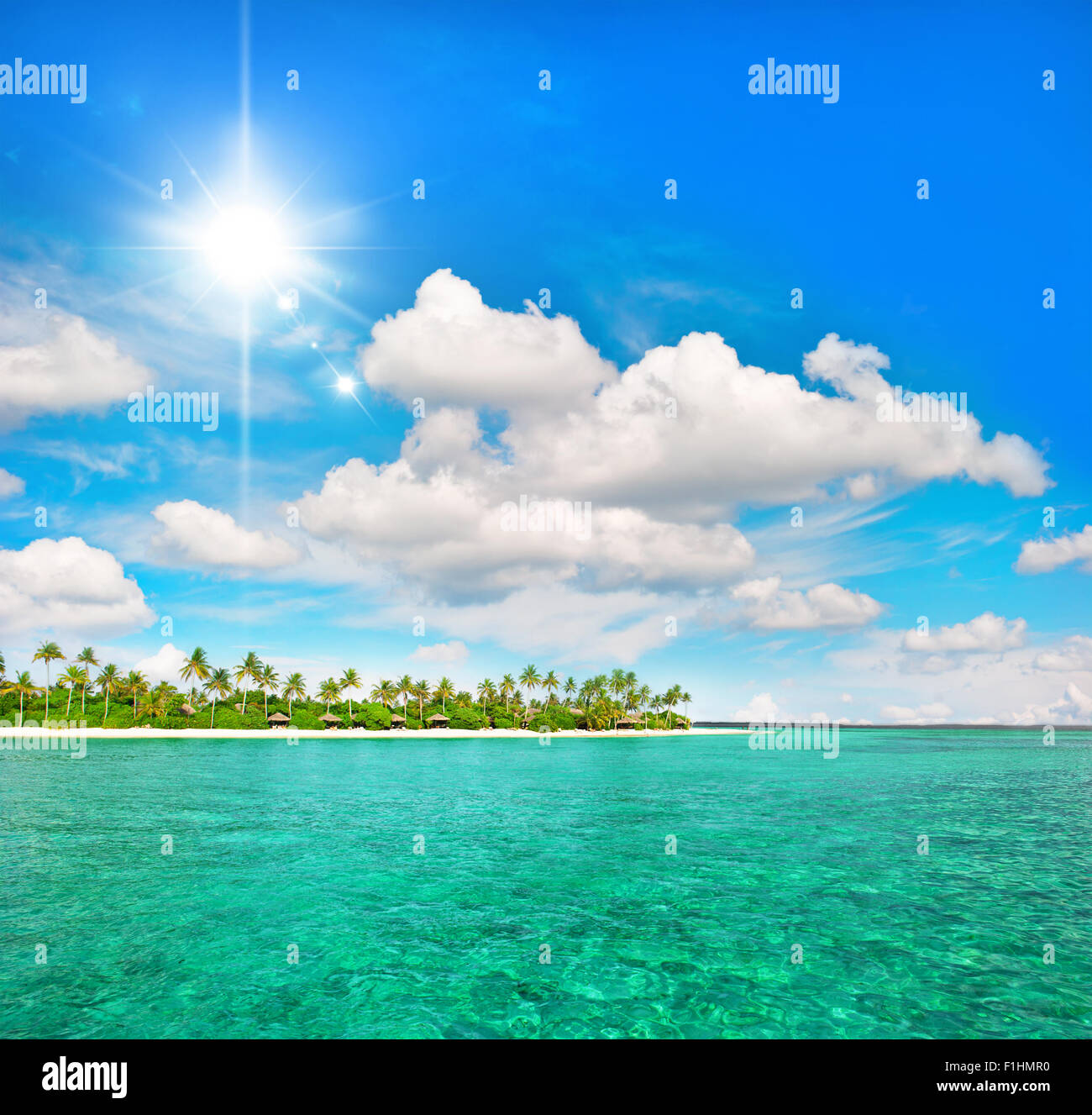 Isola tropicale spiaggia con palme sole e cielo blu Foto Stock