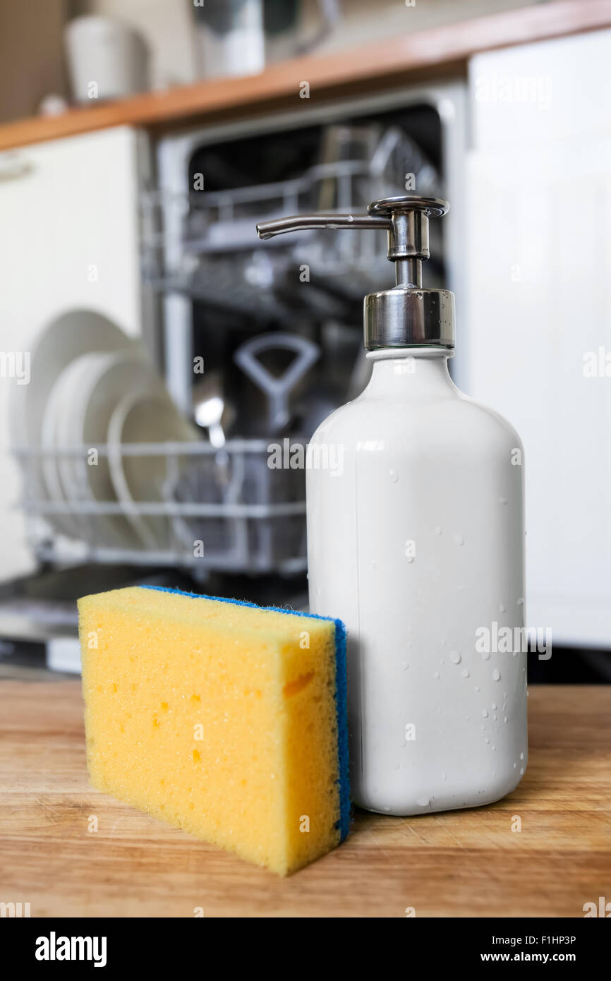 Lavastoviglie una spugna con sapone in tubo erogatore su sfondo di aperto macchina lavastoviglie dopo il processo di pulitura. Tempo di tecnologia Foto Stock