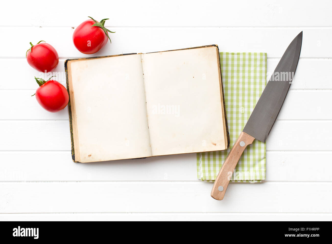 Cookbook e pomodori sul tavolo da cucina Foto Stock