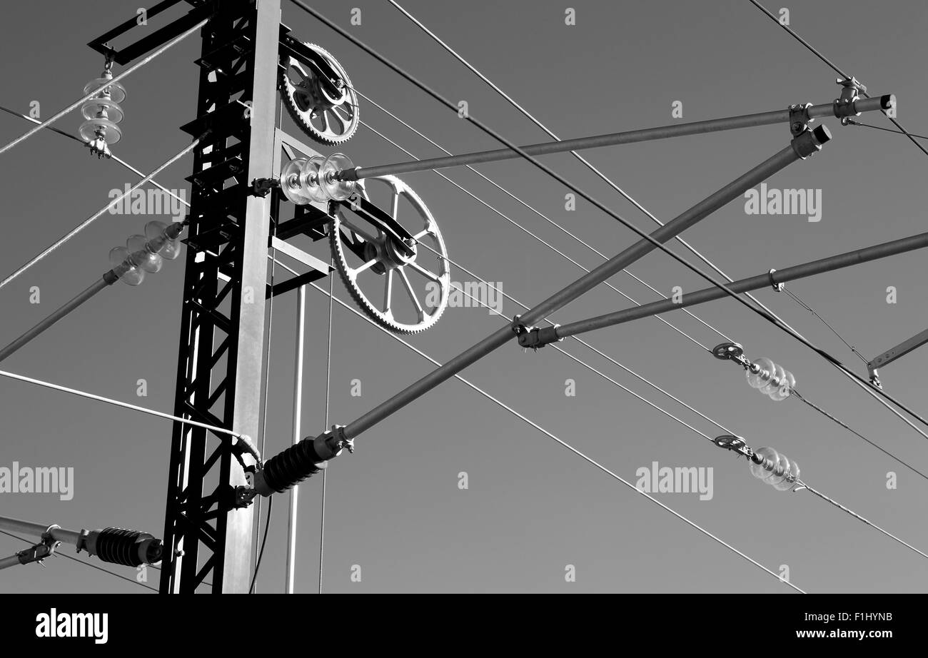 Impianto elettrico della trasmissione di energia per ferrovia in bianco e nero isolato sul cielo grigio Foto Stock