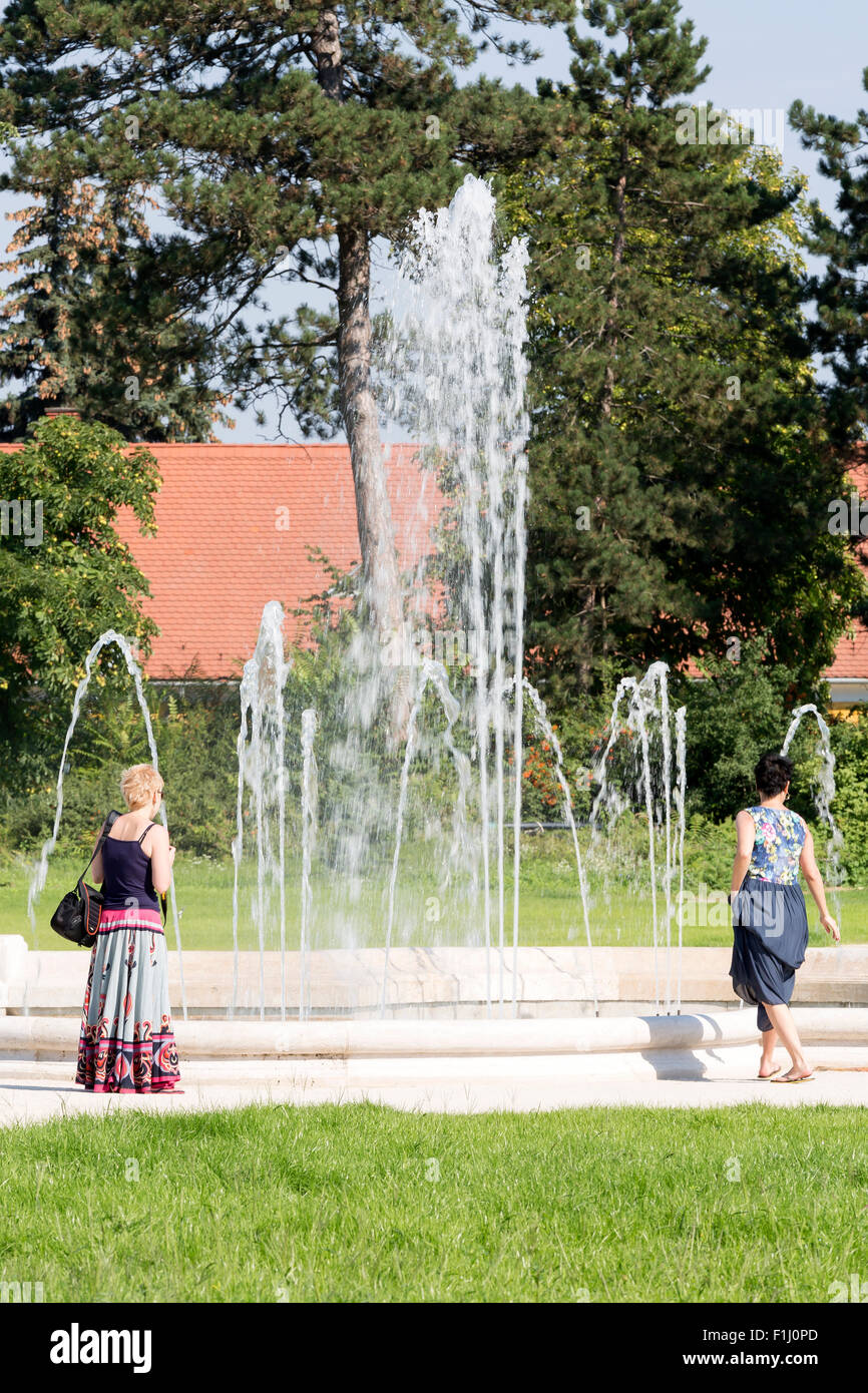 Due signore visualizzando la fontana e il giardino formale a Palazzo Festetics a Keszthely vicino al lago di Balaton, Zala county, Ungheria Foto Stock