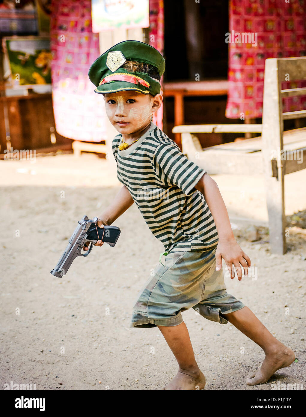 Bambino birmano con pistola campo militare Myanmar Foto Stock