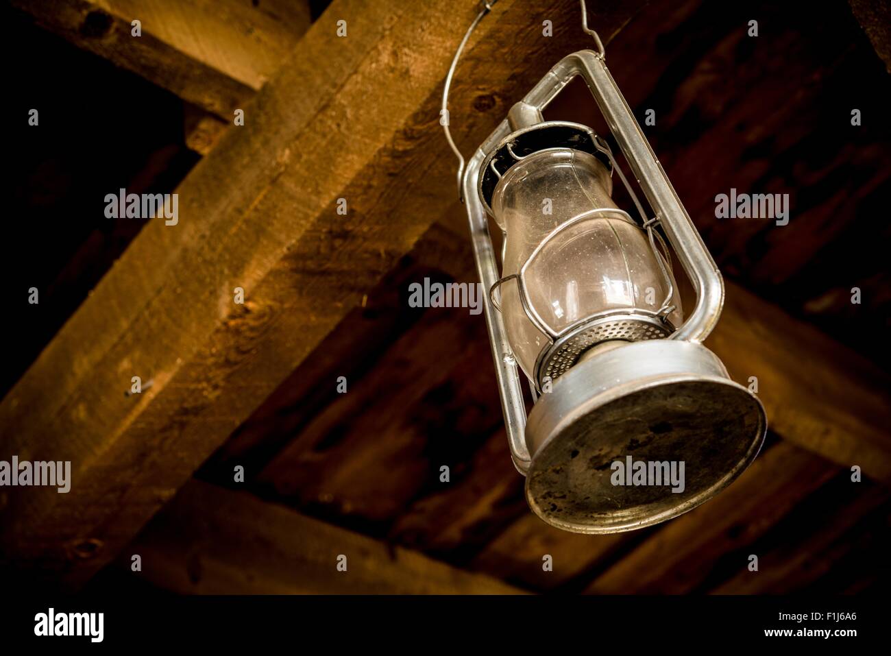 Olio lampada Impiccati nel granaio in legno. Lanterna Vintage Closeup. Foto Stock