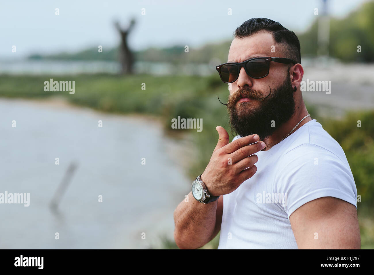 American Uomo Barbuto di toccare la sua barba Foto Stock