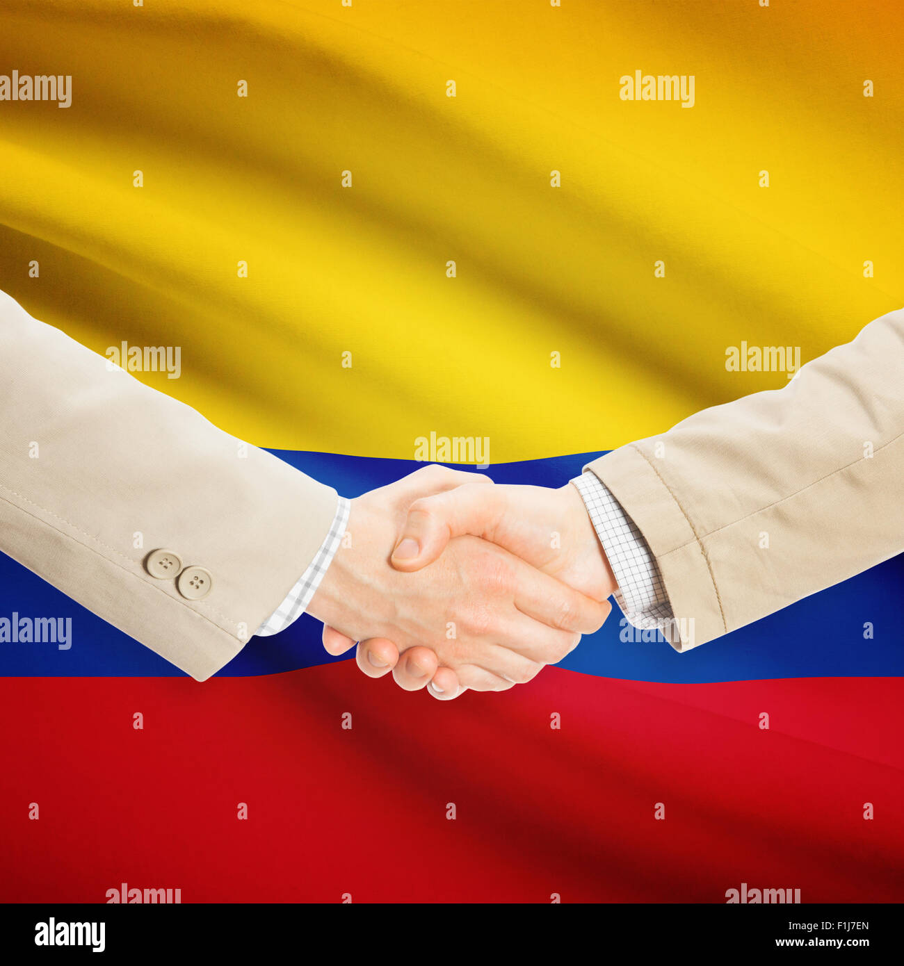Imprenditori stringono le mani con bandiera su sfondo - Colombia Foto Stock