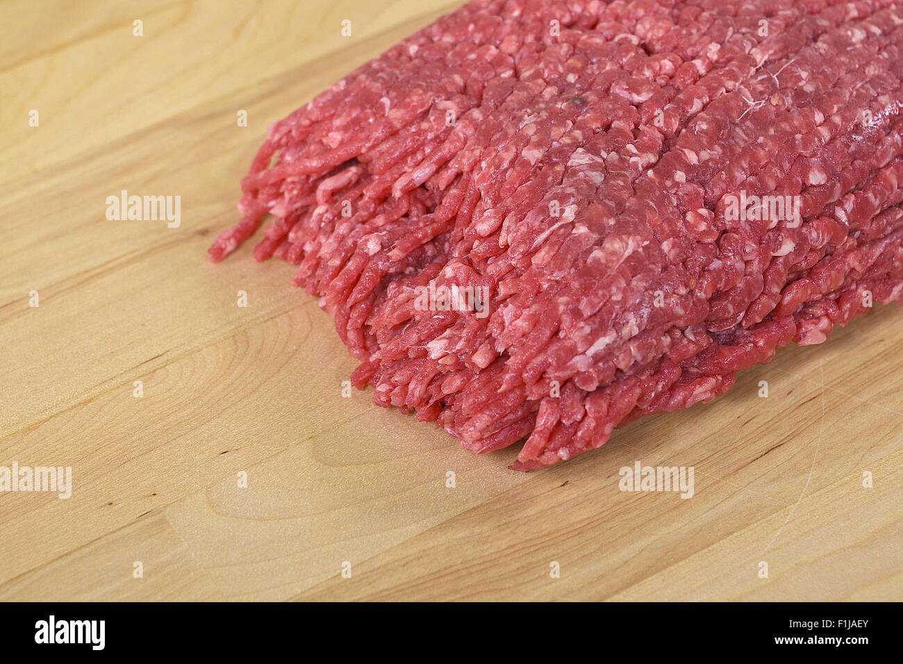 Raw hamburger di manzo su un macellaio in legno blocco. Foto Stock