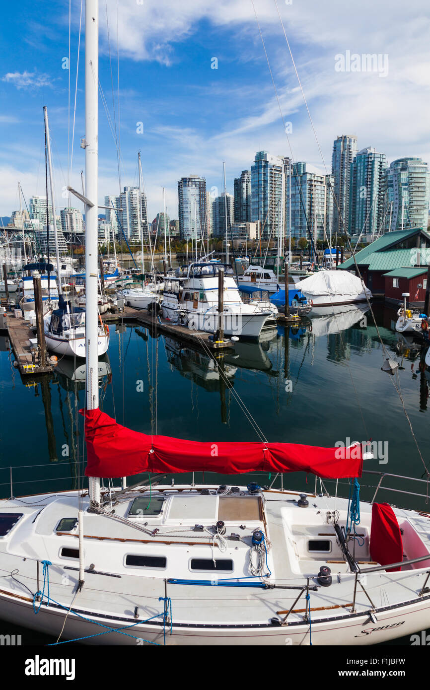 Piccolo yacht con una vibrante red sail coperchio in una marina su false creek, Vancouver Foto Stock