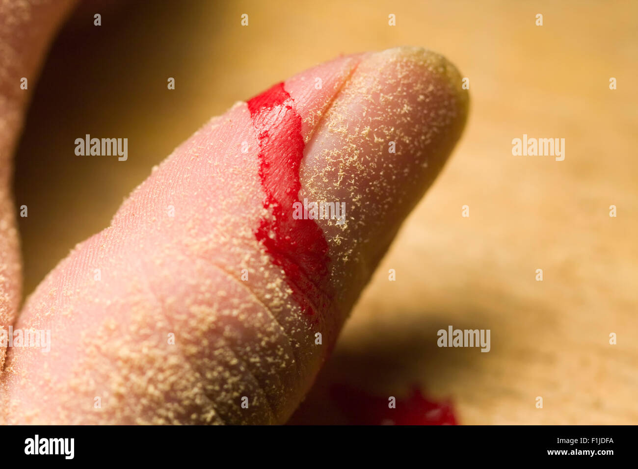 L'uomo con il pollice coperto di segatura con il sangue da un recente lesioni durante la lavorazione del legno Foto Stock