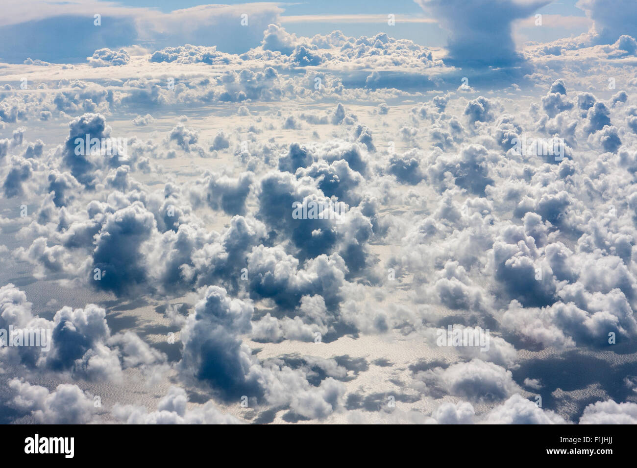 Cumulus nuvole visto da sopra il canale della Manica. Direzionale difficili la luce del sole sulle nubi con cielo azzurro sopra. Foto Stock
