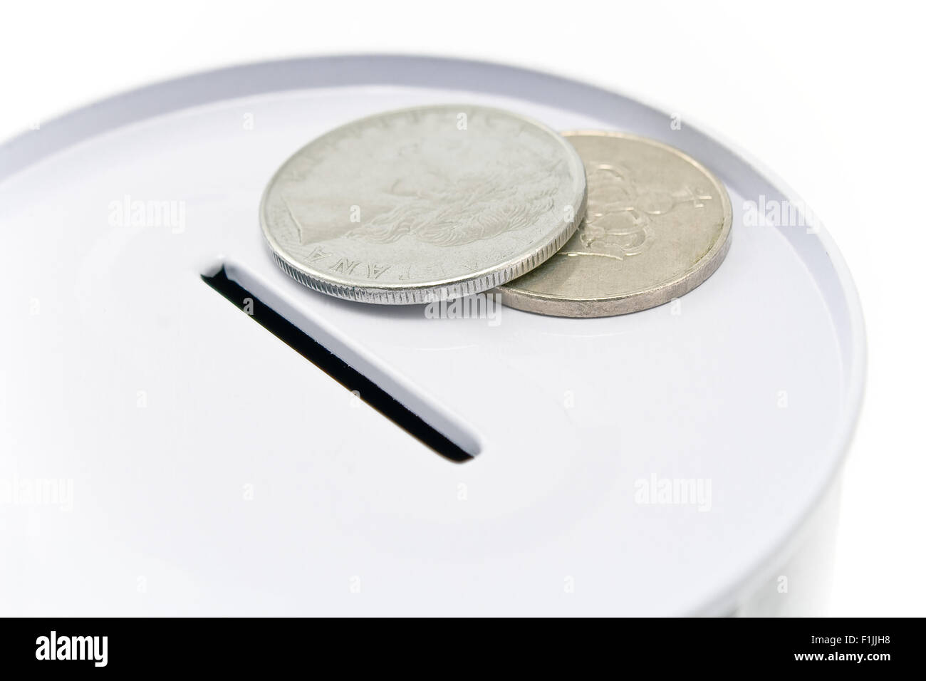 Il denaro di stagno cassetta con le monete su bianco Foto Stock
