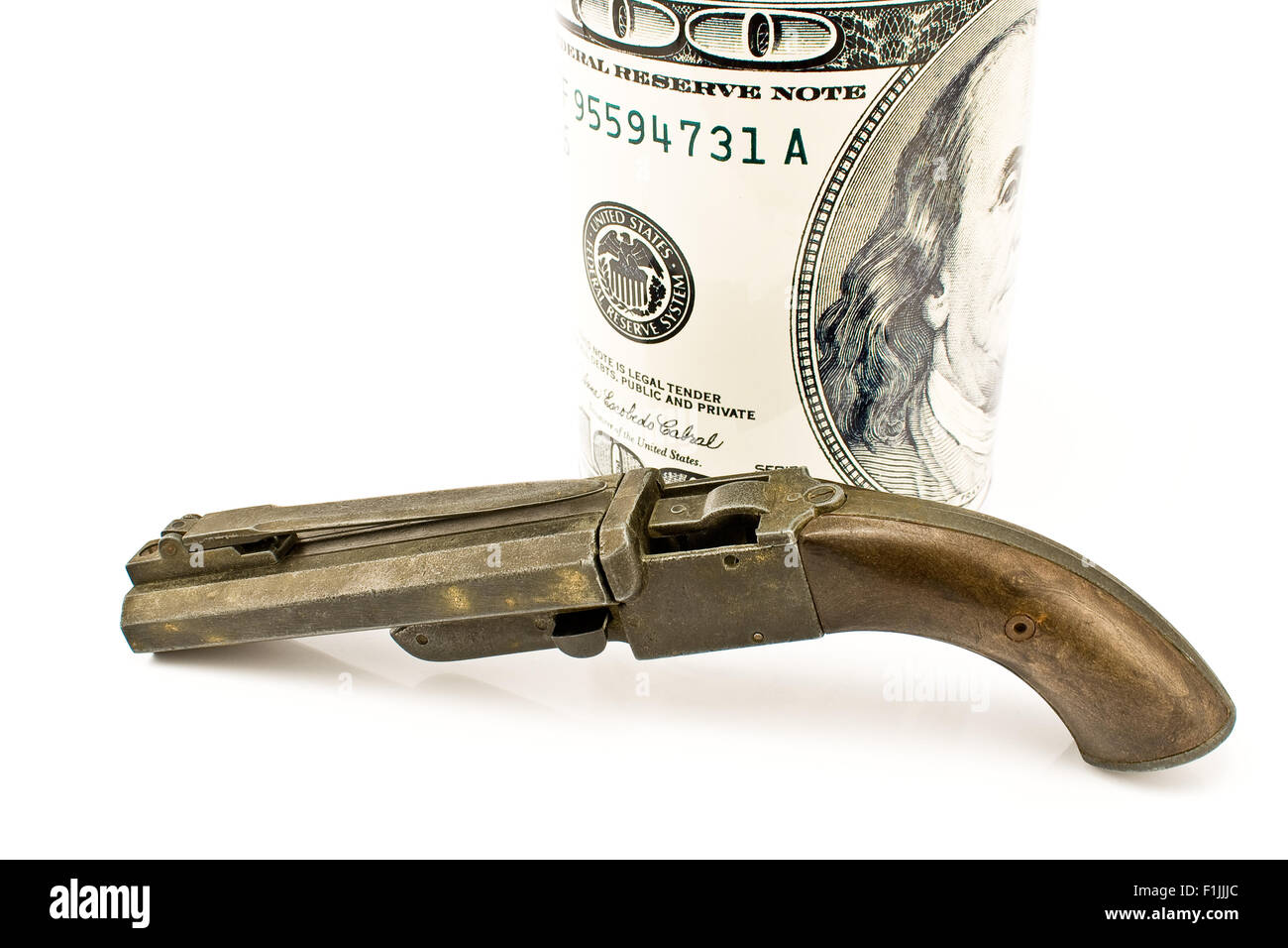 Vecchia pistola con centinaia di dollari isolato su bianco Foto Stock