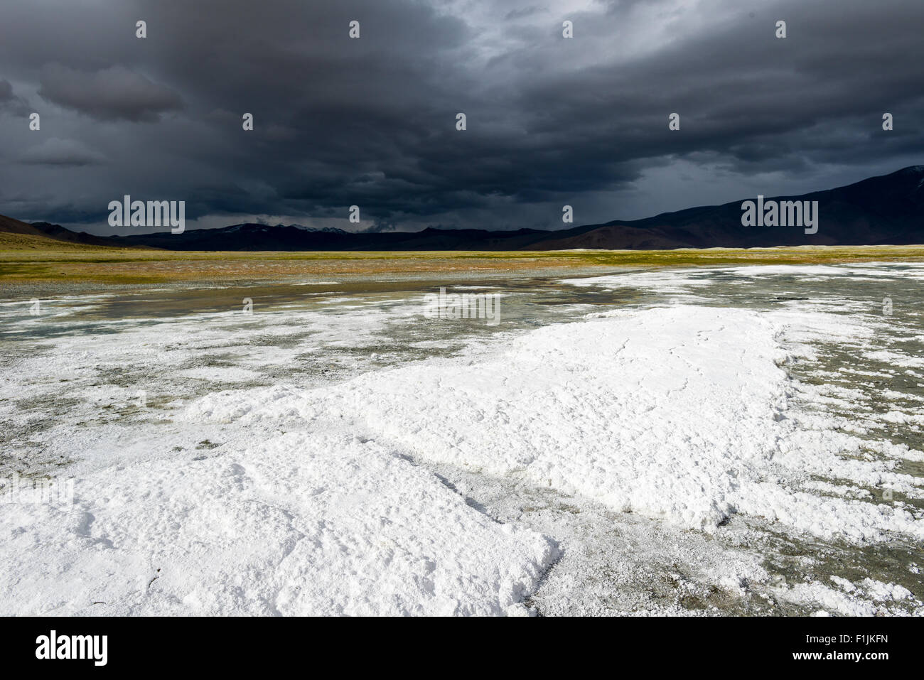 Strati di sale, paesaggio arido e nuvole scure a Tso Kar, una fluttuazione di Salt Lake, 4,530 m, area Changtang, Thukje Foto Stock
