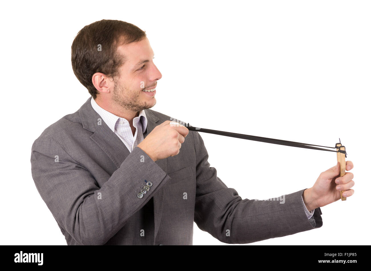 Bel buisness uomo sorridente concentrata di puntamento di un slingshot isolate su sfondo bianco Foto Stock