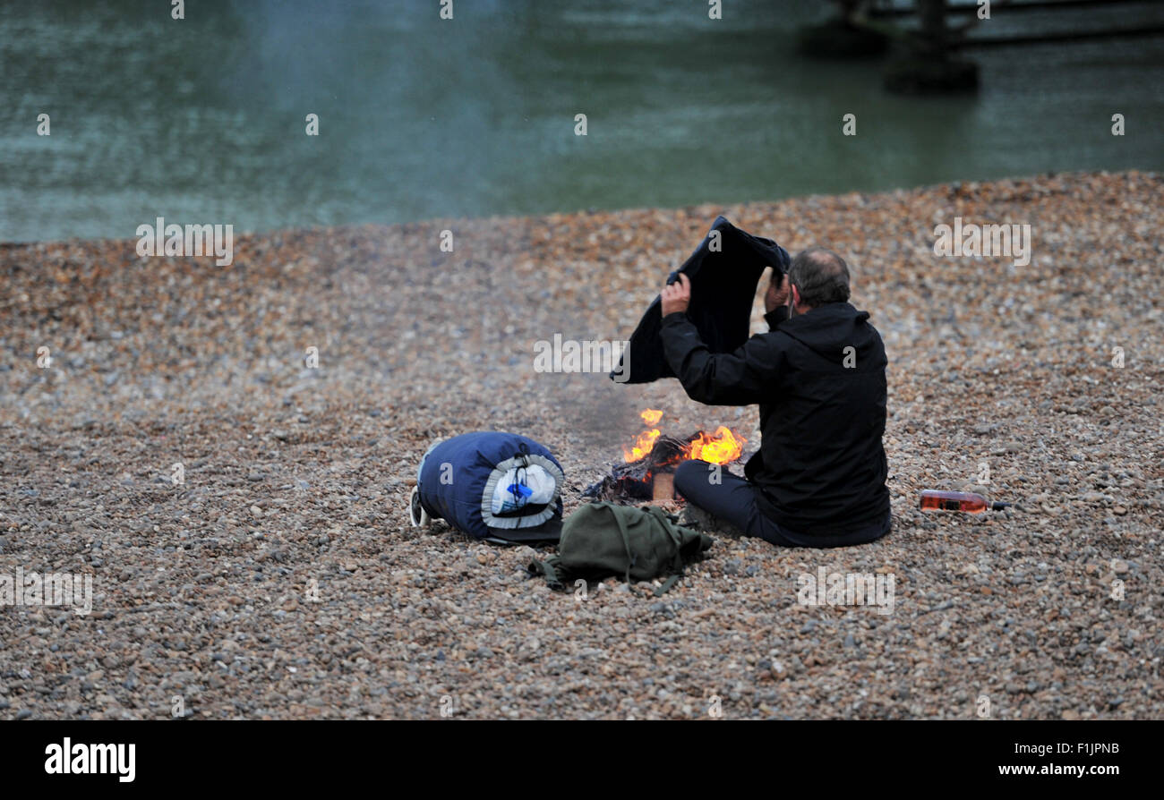 Brighton, Regno Unito. Il 3 settembre 2015. Un uomo dorme ruvido sulla spiaggia di Brighton mantiene caldo accanto a un incendio questa mattina Credito: Simon Dack/Alamy Live News Foto Stock