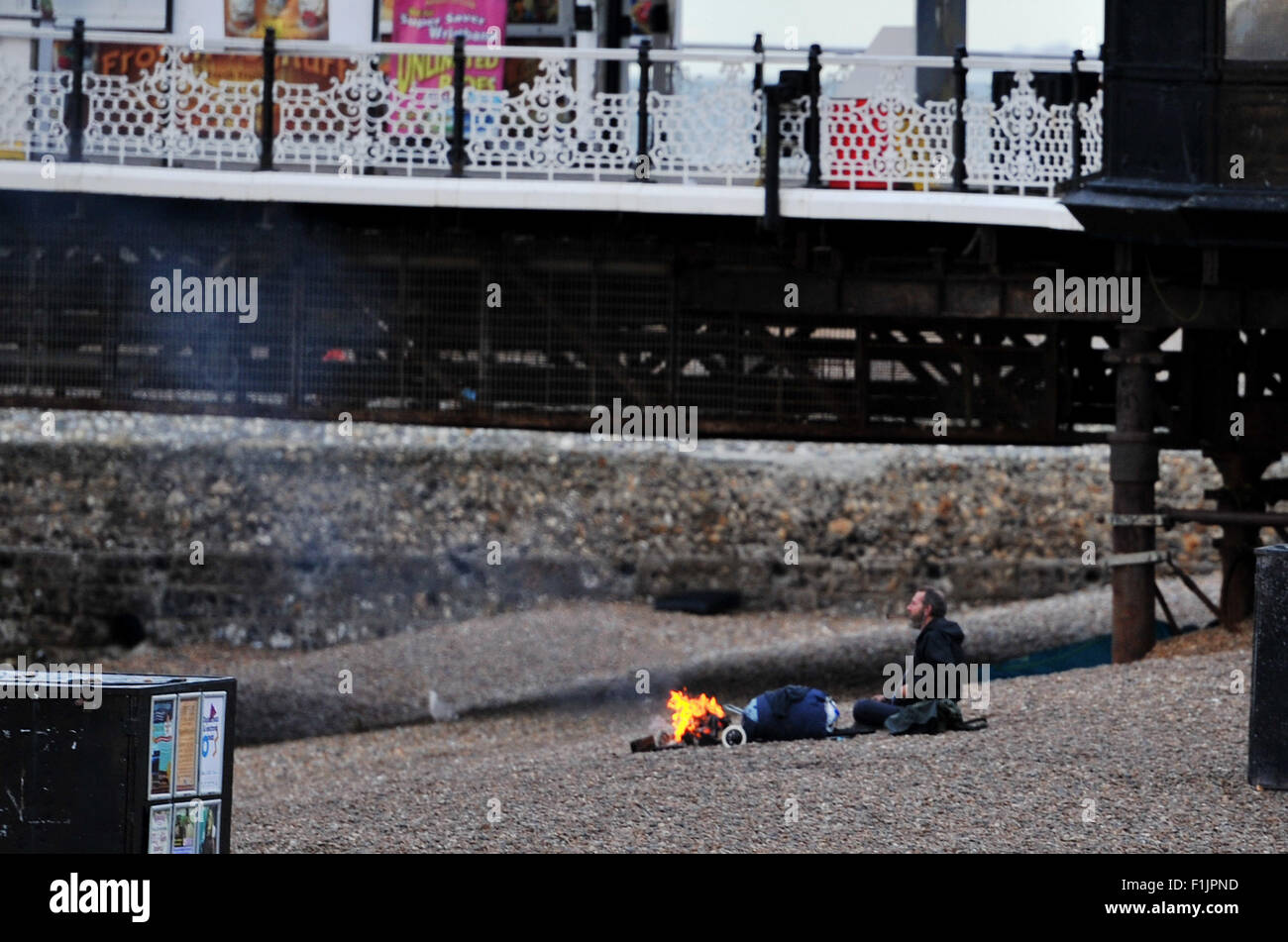 Brighton, Regno Unito. Il 3 settembre 2015. Un uomo dorme ruvido sulla spiaggia di Brighton mantiene caldo accanto a un incendio questa mattina Credito: Simon Dack/Alamy Live News Foto Stock